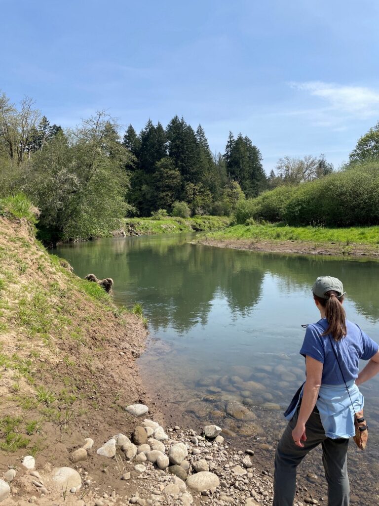 harma A photo of a person standing next to a river.